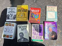 All eight books grouped on ground showing front covers and binding types