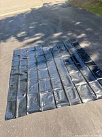 Full view of black rubber liner laid flat showing size and panel seams