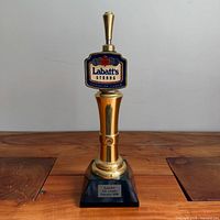 Full view of trophy showing pump handle, sign, and base