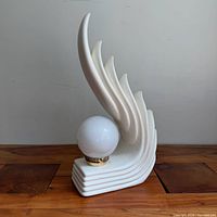 Front view of sculptural ceramic lamp with globe shade