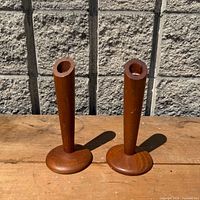 Both teak candle holders front view on wood surface