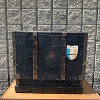 Front view of black wood shipping crate showing "France" paper label