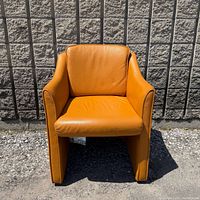 Front view of orange Himolla armchair on wheels