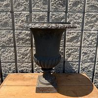Full view of cast iron urn on pedestal base