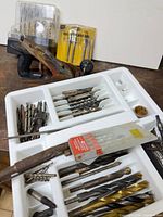 Overview of drill bits in plastic tray with hand plane