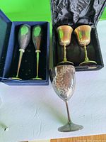 Two tapered stem goblets in blue case, two rounded chalices in black case, single engraved goblet in foreground