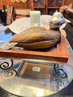 Full view of duck decoy on wooden base