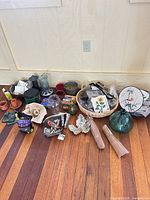Lot overview on wood floor showing feeders, candles, glass bottle, plate, basket and more