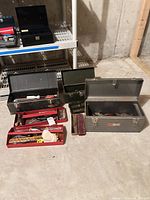 Overall view of three metal tool boxes and red trays with tools