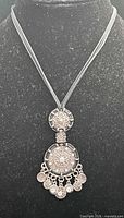 Full view of necklace on bust, showing pendant and cord