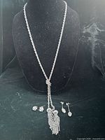 Full view of necklace draped on bust with all earrings displayed