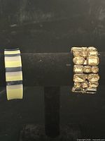 Both bracelet and bangle displayed side by side on stand