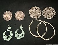 All four pairs of earrings arranged on black background