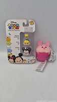 Front view of sealed Series 1 vinyl 3-pack alongside Piglet plush with tags