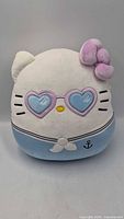 Front view of Hello Kitty Squishmallow showing heart sunglasses, sailor collar, anchor emblem