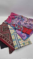 Stack of four scarves showing variety of patterns