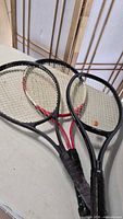 Three racquets stacked showing frames, strings and grips