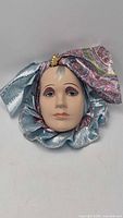 Full view of ceramic lady wall mask with fabric ruffle and headscarf