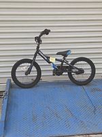 Full left side view of 16" kids bicycle on blue ramp