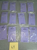 Front view showing 12 Claire’s packaged Sagittarius necklace & earring sets