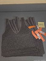 Stack of gray Colsie tank tops showing front view and tags