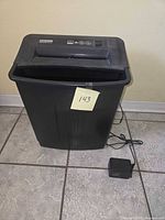 Front view of Fellowes PS-40 shredder with adapter placed beside