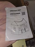 User manual on top of folded pink fabric canopy