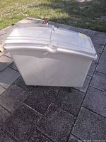 Side view of storage bin showing wheels and clear hinged lid