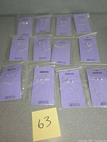 All twelve packaged necklace and earring sets laid out with lot tag