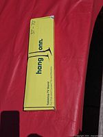 Closed yellow box showing hang onn. tabletop TV stand text