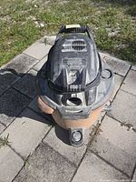 Top view showing RIDGID branding, black lid, missing hose port cap, heavy dust