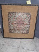 Full shot of square wall art showing frame, burlap mat and central patterned wood panel