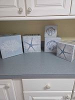 Five decorative boxes on countertop showing designs and relative sizes