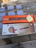 Front view of both retail boxes: Hang wall mount and Teshark hinge tool