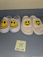 Front view of both slipper pairs showing smiley face graphics