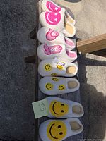 All four pairs of slippers lined on bench showing designs