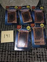 Front view of five sealed Yu-Gi-Oh! blister packs