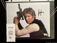 Front view of signed 8x10 photo in sleeve with COA visible
