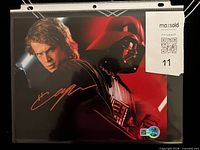 Front view of signed 8x10 photo in sleeve with COA visible