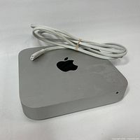 Top view of silver Apple Mac mini with power cord