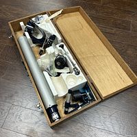 Open wood case showing main tube, accessories, foam inserts