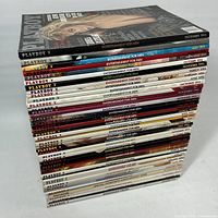 Stack of Playboy magazines showing top cover and spines, approx 30 issues