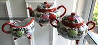 Teapot, sugar bowl, creamer side view showing shape and decoration