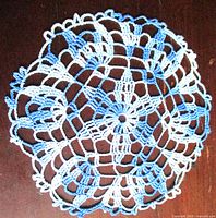 Full view of round blue and white crochet doily