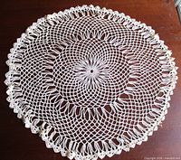 Full view of circular crochet doily on table surface