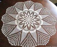 Full view of round crochet doily displayed flat