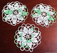 All three green and white crochet doilies on tabletop