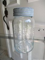 Front view of clear Crown Mason quart jar with lid showing embossed crown and CROWN lettering