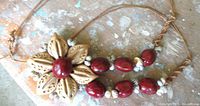 Pendant and bead section resting on surface highlighting texture and colors.