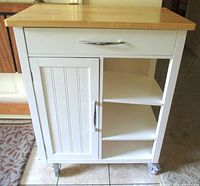 Full frontal view of cart showing drawer, cabinet door, open shelves, wood top and casters